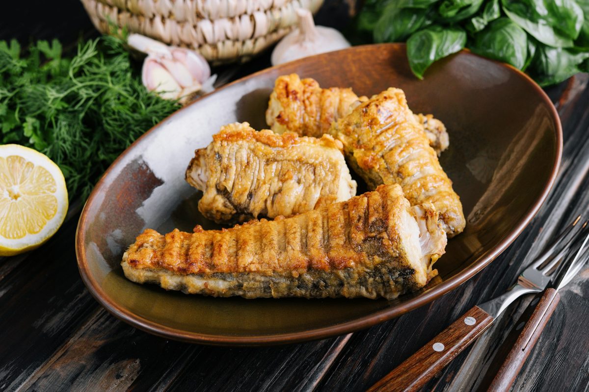 Cooked, fried pieces of fish on a ceramic plate