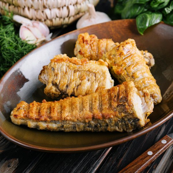 Cooked, fried pieces of fish on a ceramic plate